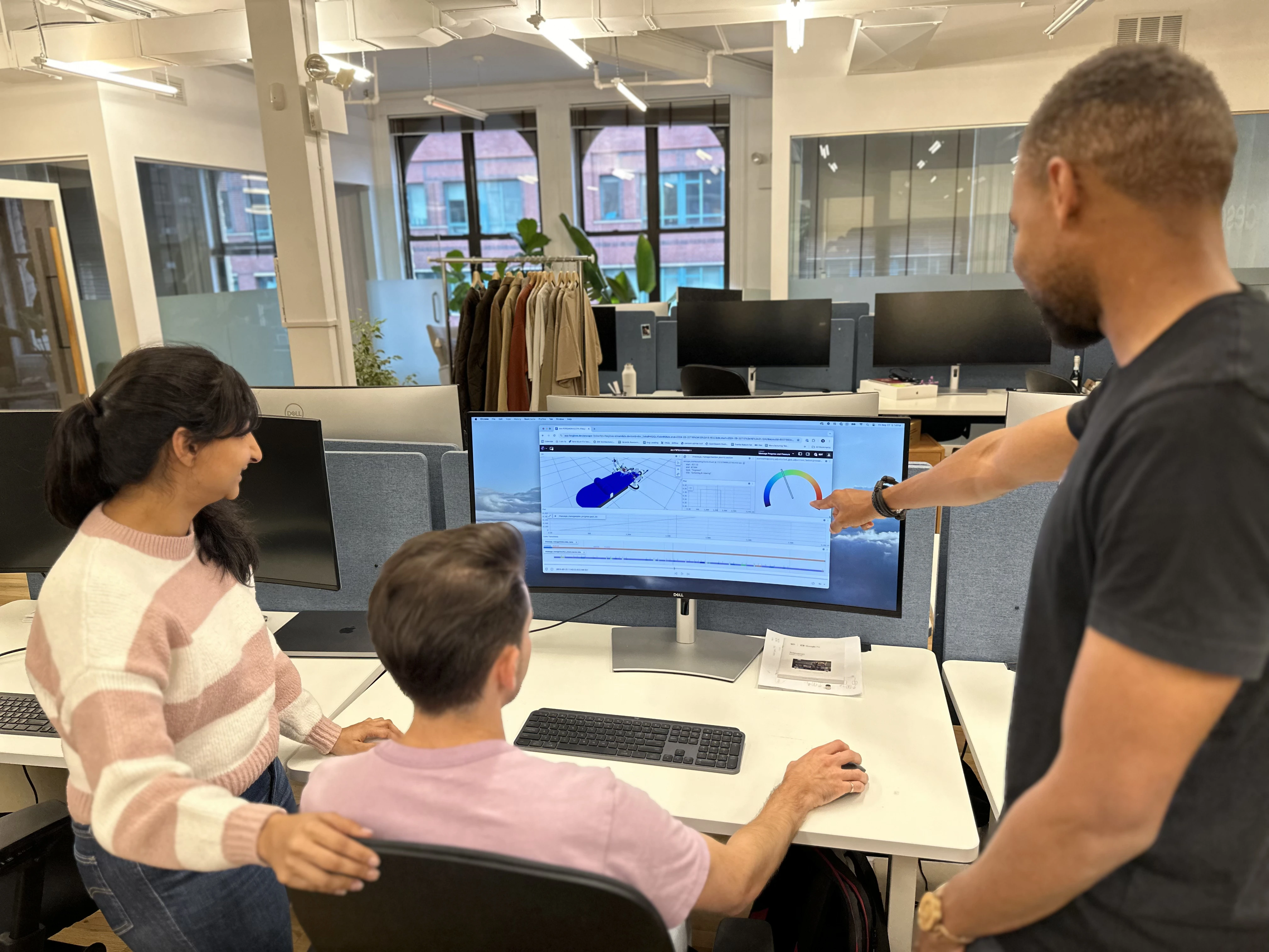 Aescape employees collaborating around the Foxglove UI.